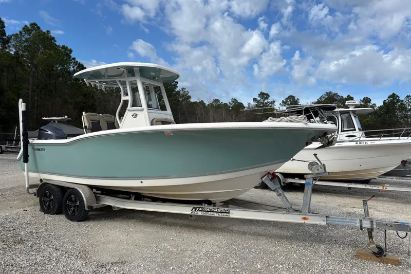 The Image of 2021 Tidewater 232 CC Adventure boat on trailer, parked outdoors under a blue sky. - 0