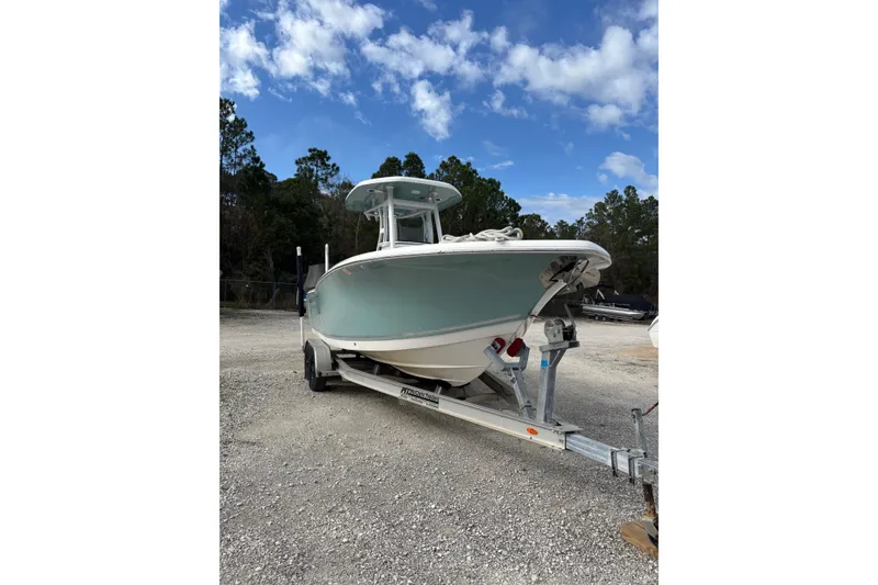 Slide: The Image of 2021 Tidewater 232 CC Adventure boat on trailer under blue sky. - 2
