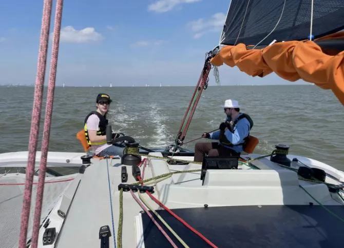 Slide: The Image of Two people sailing a 2022 Corsair 880 Sport on open water. - 11