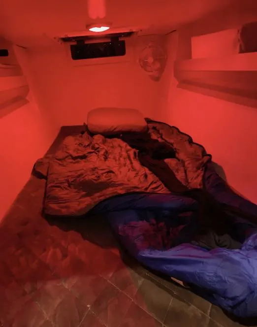 Slide: The Image of Interior cabin of 2022 Corsair 880 Sport, featuring cozy sleeping area with red lighting. - 16