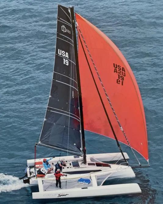 Slide: The Image of 2022 Corsair 880 Sport sailboat with red and black sails on open water. - 3