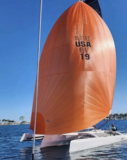 Slide: The Image of 2022 Corsair 880 Sport sailboat with orange sail on calm water. - 4