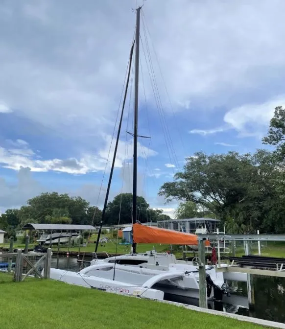 Slide: The Image of 2022 Corsair 880 Sport sailboat docked, featuring a sleek design and vibrant orange sail cover. - 6