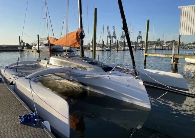 Slide: The Image of 2022 Corsair 880 Sport trimaran docked at marina with orange sail. - 9