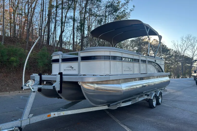 Slide: The Image of 2023 Bennington 23 SSR S pontoon boat on trailer in wooded area. - 6