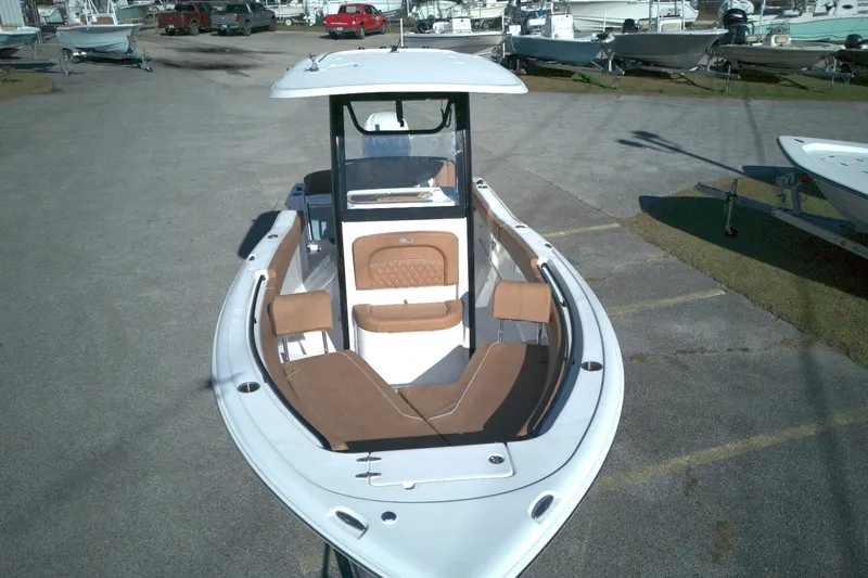 Slide: The Image of 2026 Sea Hunt Ultra 245 SE boat with spacious seating, parked in a marina. - 10