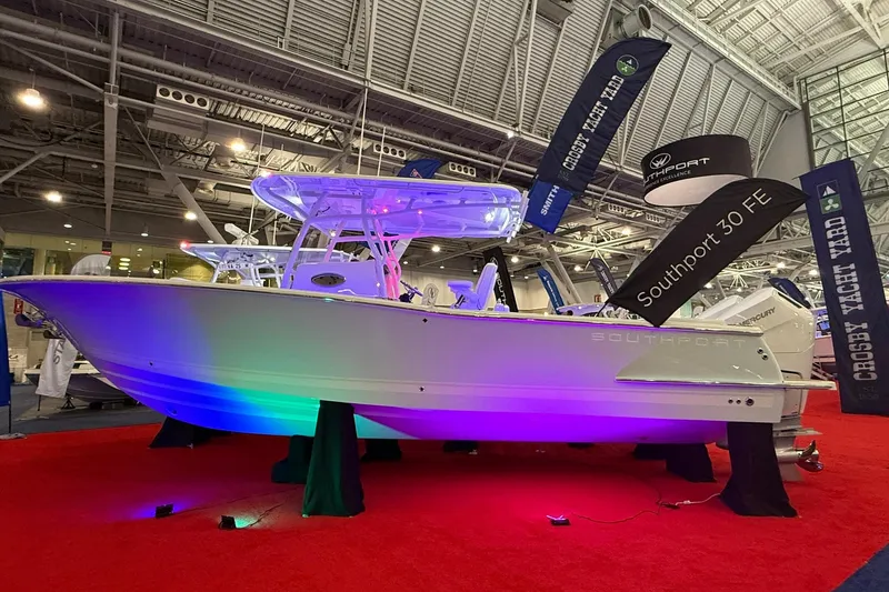 The Image of 2026 Southport 30 FE boat displayed with colorful lighting at an indoor exhibition. - 0