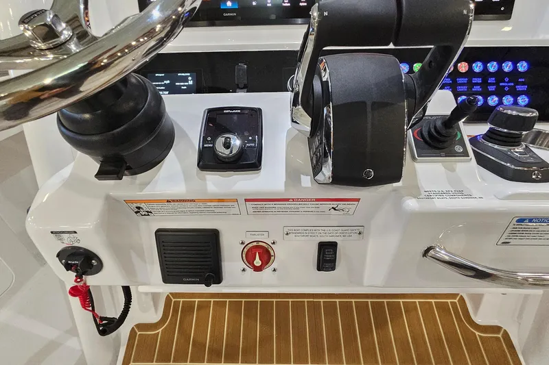 Slide: The Image of 2026 Southport 30 FE boat dashboard with dual navigation screens and steering wheel. - 16