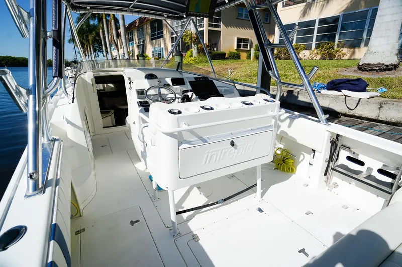 Slide: The Image of 2003 Intrepid 310 Walkaround boat interior with steering wheel and seating area. - 10