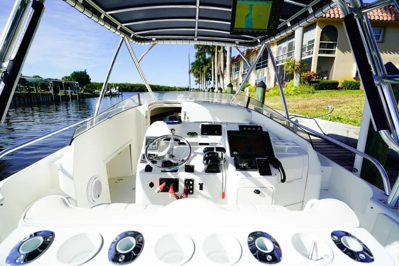 Slide: The Image of 2003 Intrepid 310 Walkaround boat interior with steering wheel and navigation equipment. - 11