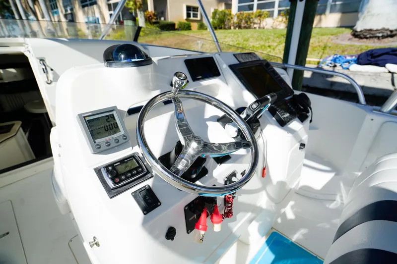 Slide: The Image of 2003 Intrepid 310 Walkaround boat helm with steering wheel and navigation instruments. - 14