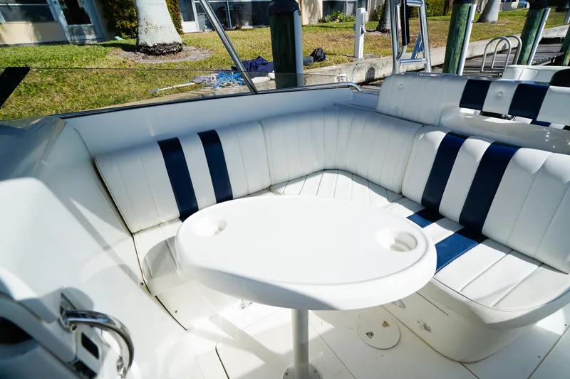Slide: The Image of 2003 Intrepid 310 Walkaround boat interior with white and blue seating and round table. - 18
