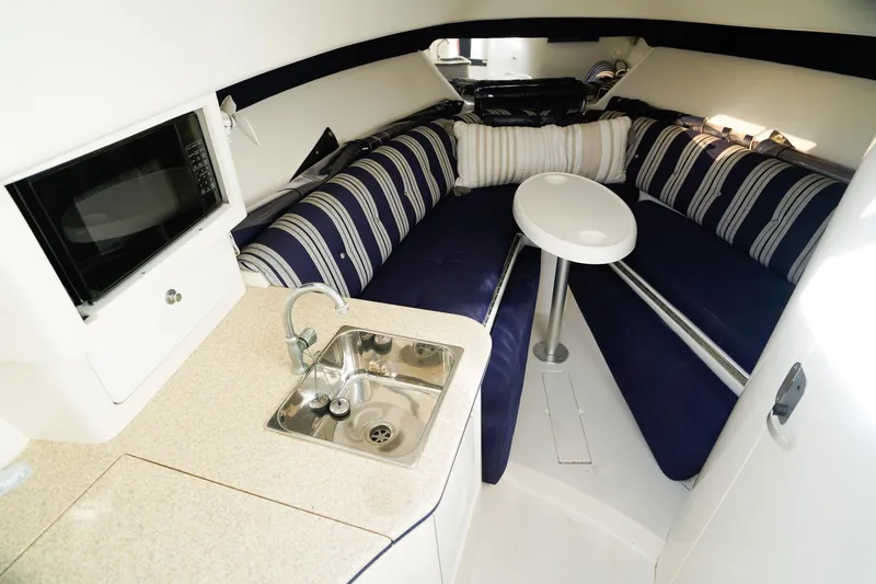 Slide: The Image of 2003 Intrepid 310 Walkaround interior with kitchenette, seating, and table. - 21