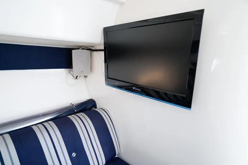 Slide: The Image of Flat-screen TV in 2003 Intrepid 310 Walkaround cabin with striped seating. - 26