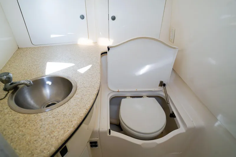 Slide: The Image of 2003 Intrepid 310 Walkaround boat bathroom with sink and toilet. - 27