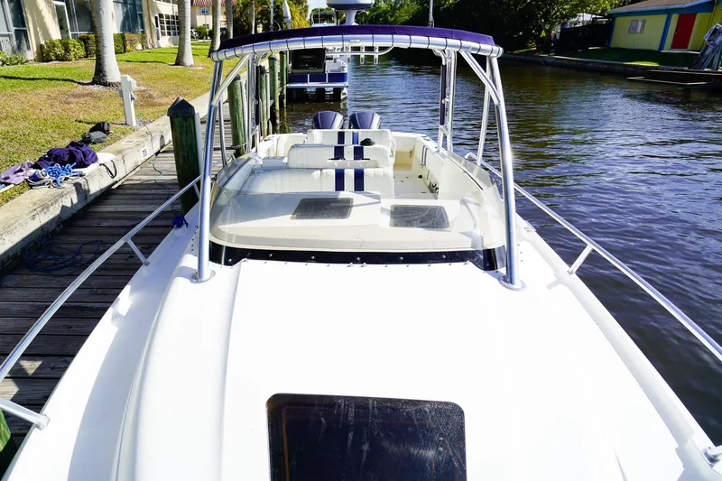 Slide: The Image of 2003 Intrepid 310 Walkaround boat docked by a canal, sunny day. - 32