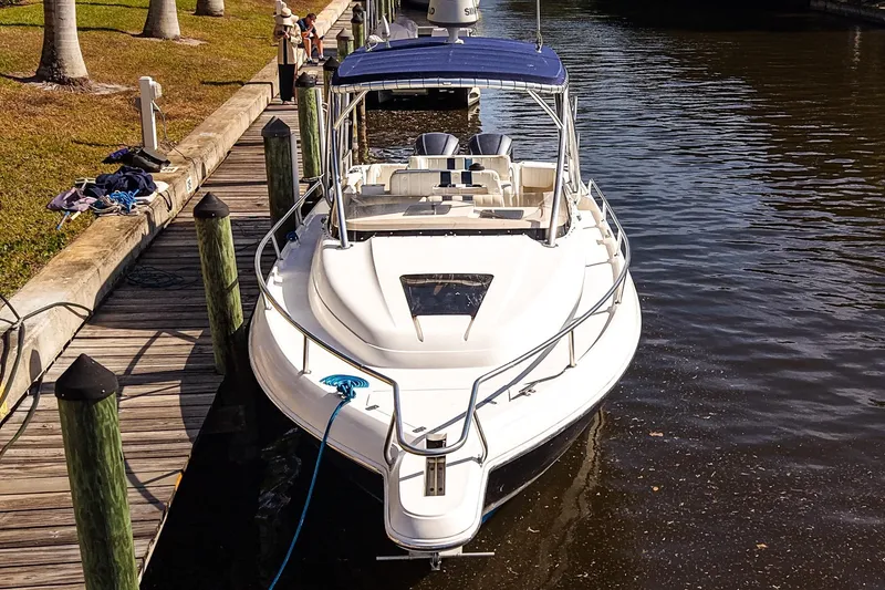 Slide: The Image of 2003 Intrepid 310 Walkaround boat docked by a wooden pier. - 35