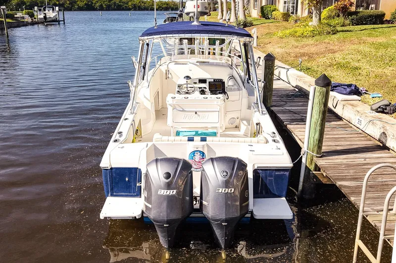 Slide: The Image of 2003 Intrepid 310 Walkaround boat docked with twin 300 horsepower engines. - 36