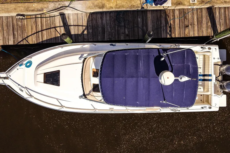 Slide: The Image of Overhead view of a 2003 Intrepid 310 Walkaround boat docked at a wooden pier. - 4