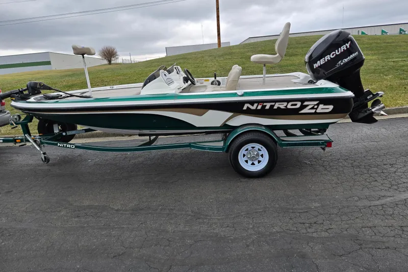 Slide: The Image of 2008 Nitro Z-6 boat with Mercury engine on trailer, parked on asphalt. - 4