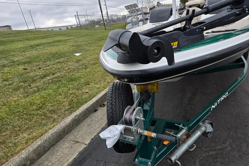 Slide: The Image of 2008 Nitro Z-6 boat on trailer, parked on pavement near grassy area. - 7