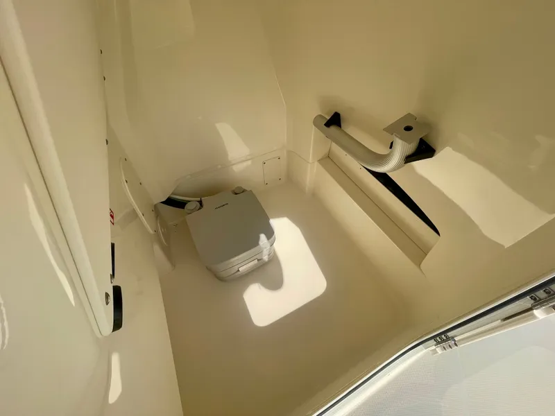 Slide: The Image of Interior of a boat cabin with a portable toilet and handrail. - 13