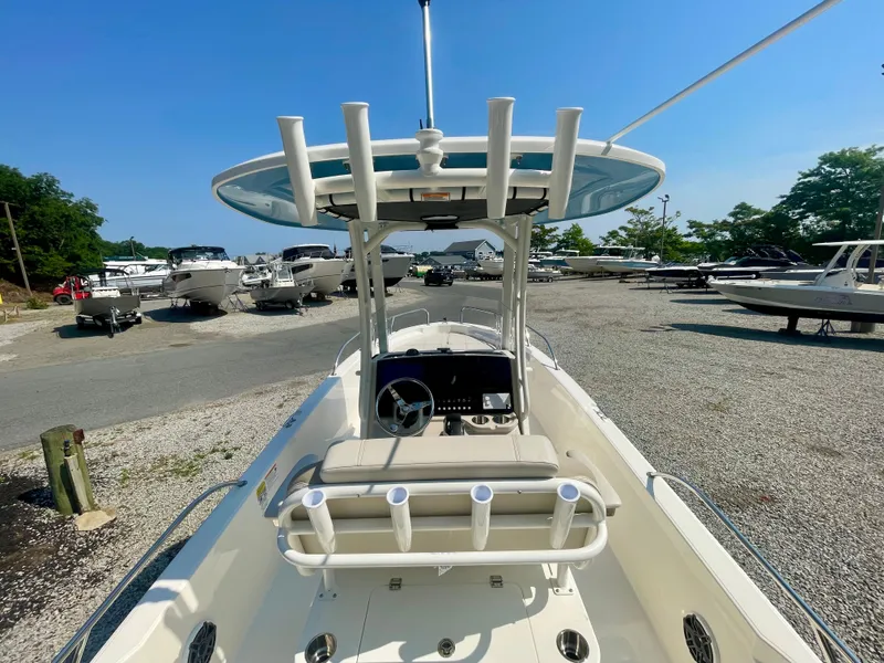 Slide: The Image of The image shows a Boston Whaler 220 Dauntless boat on a gravel lot, surrounded by other boats. - 6