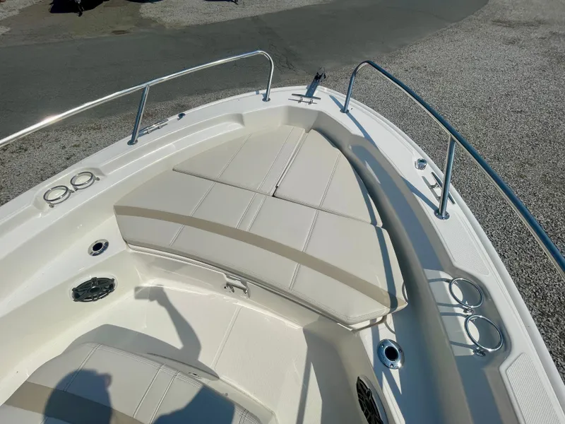 Slide: The Image of The image shows the bow of a Boston Whaler 220 Dauntless with beige cushions and stainless steel railing. - 17