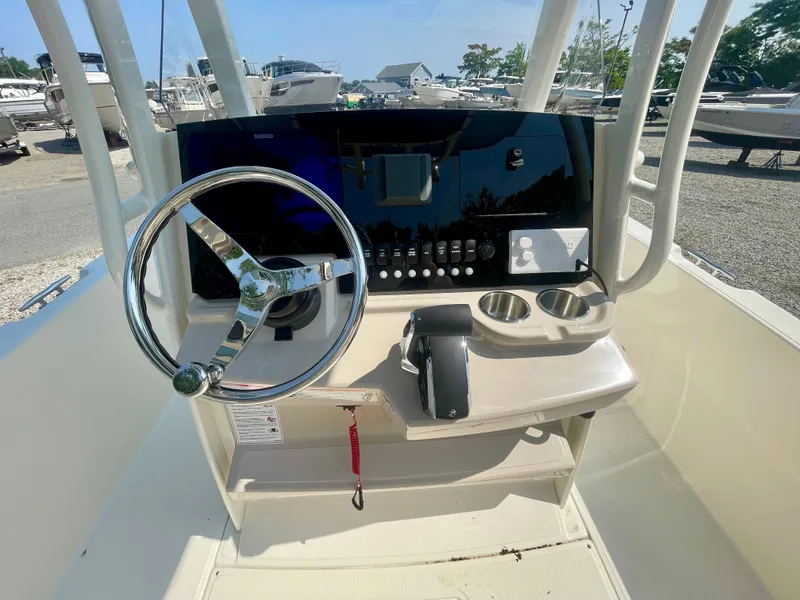Slide: The Image of The image shows the helm of a Boston Whaler 220 Dauntless boat with a steering wheel and instruments. - 11