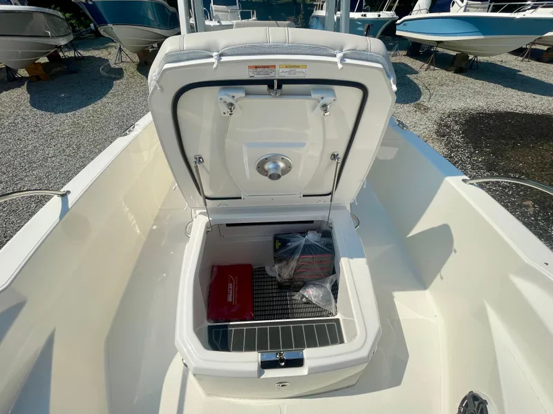 Slide: The Image of An open storage compartment on a Boston Whaler 220 Dauntless boat, surrounded by other boats. - 16