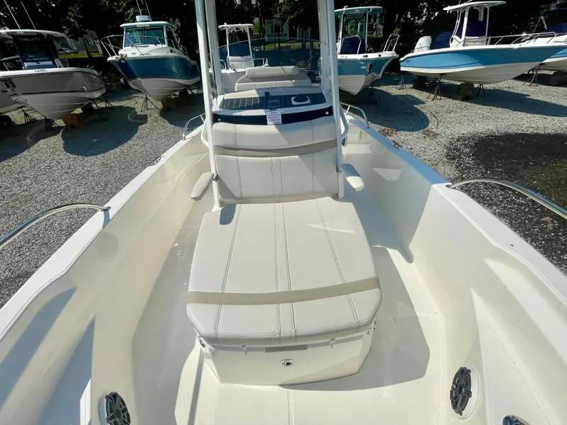 Slide: The Image of The image shows the deck of a Boston Whaler 220 Dauntless boat with white upholstery. - 15