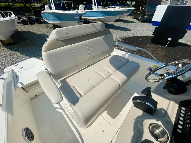 Slide: The Image of The image shows the helm of a Boston Whaler 220 Dauntless with beige upholstered seating. - 9