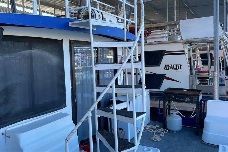 Slide: The Image of 1986 Boatel Hercules houseboat with exterior stairs and deck equipment. - 4