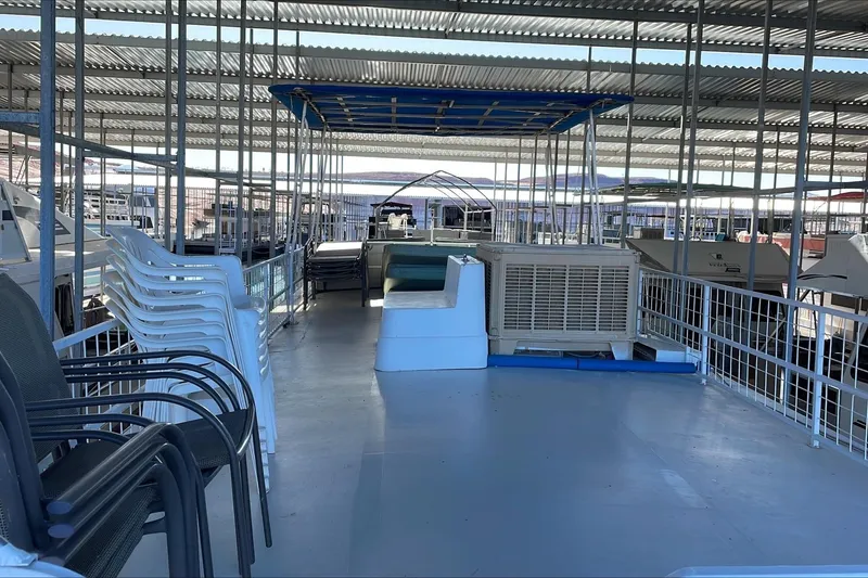 Slide: The Image of 1986 Boatel Hercules boat interior with stacked chairs and covered deck area. - 5