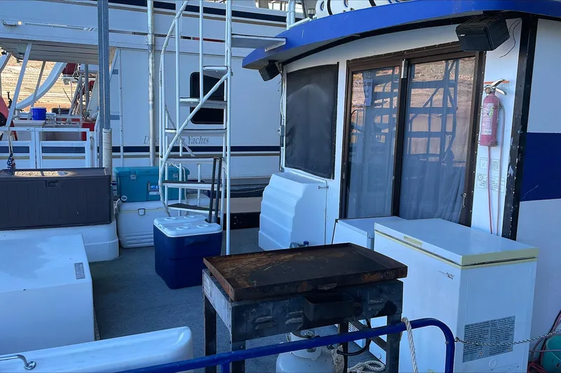 Slide: The Image of 1986 Boatel Hercules houseboat deck with grill, coolers, and storage units. - 7