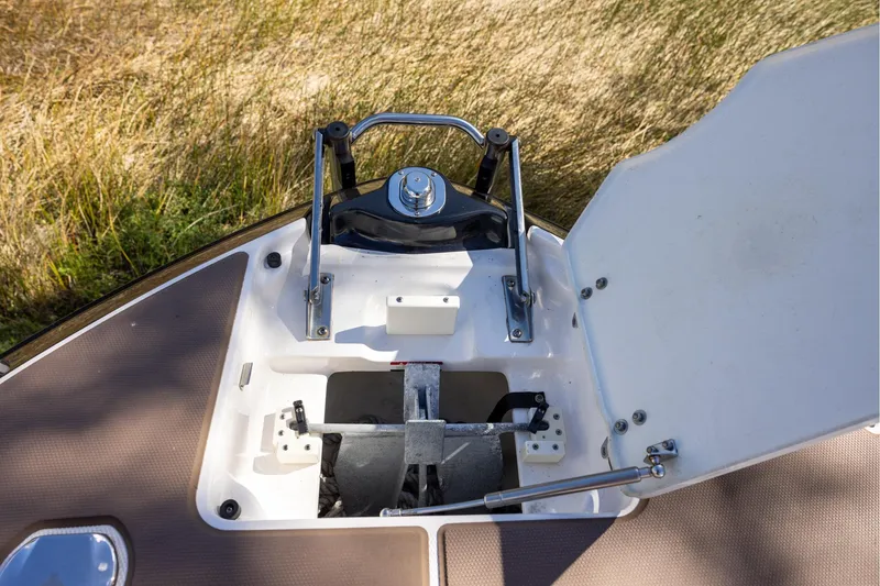 Slide: The Image of Open anchor compartment on 2018 Chaparral 264 Sunesta boat, showing anchor and mechanism. - 12