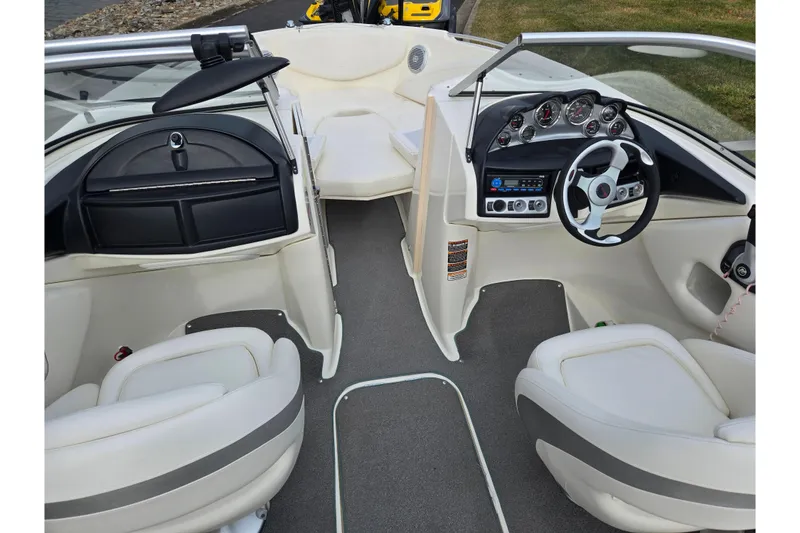 Slide: The Image of Interior of a 2009 Bayliner 225 boat with steering wheel and seating. - 12