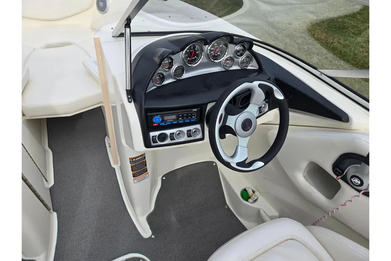 Slide: The Image of 2009 Bayliner 225 boat dashboard with steering wheel and instrument panel. - 14