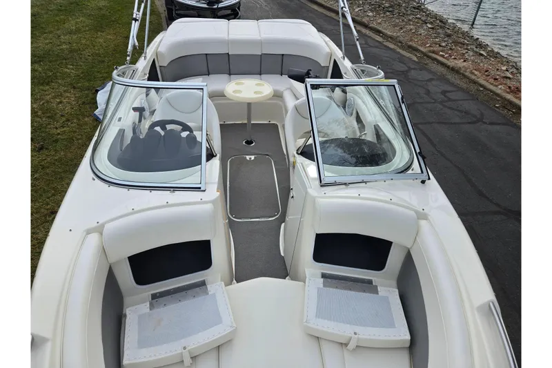 Slide: The Image of 2009 Bayliner 225 boat interior with seating, steering wheel, and open windshield. - 20