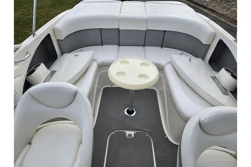 Slide: The Image of 2009 Bayliner 225 boat interior with white seating and a central table. - 22