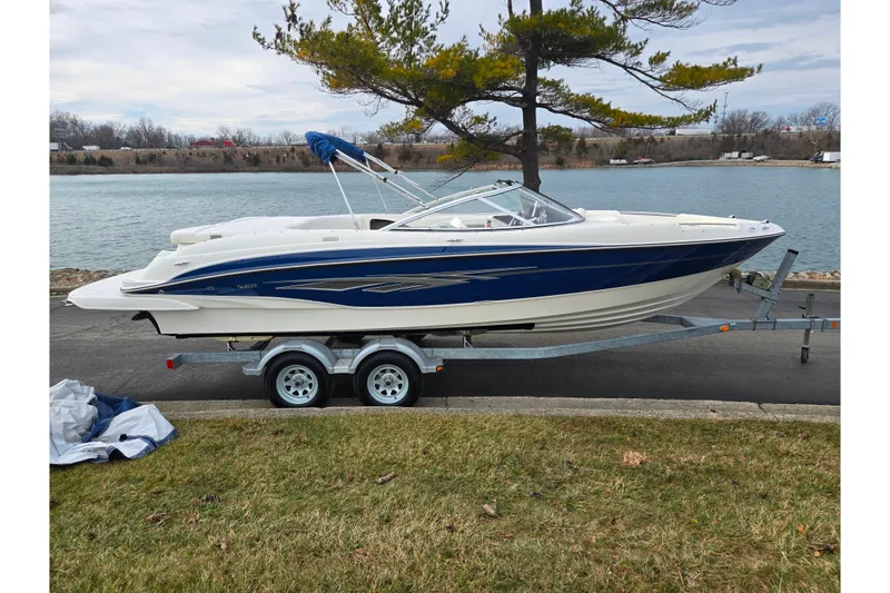 Slide: The Image of 2009 Bayliner 225 boat on trailer by a lakeside, ready for launch. - 9