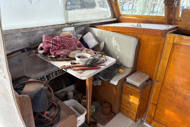 Slide: The Image of Interior of a 1979 Custom Chesapeake Sportfish Cruiser with cluttered table and wooden cabinetry. - 10