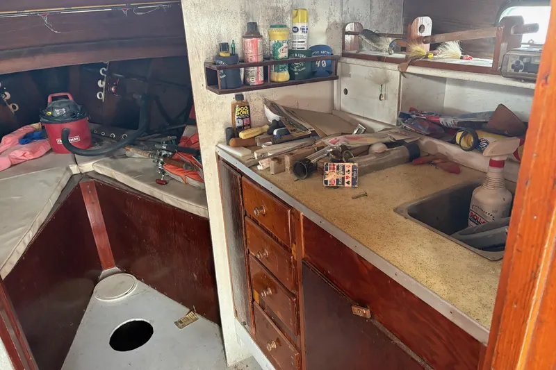 Slide: The Image of 1979 Custom Chesapeake Sportfish Cruiser interior with cluttered kitchen and storage area. - 11