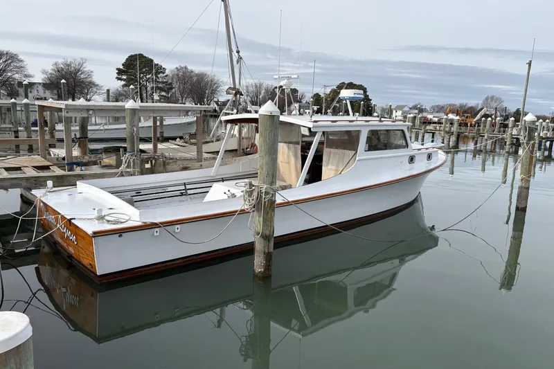 Slide: The Image of 1979 Custom Chesapeake Sportfish Cruiser docked at a marina, calm water reflection. - 4