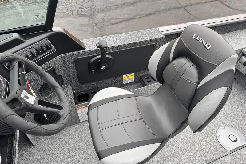 Slide: The Image of 2026 Lund 1775 Impact XS Sport boat interior with steering wheel and seat. - 12