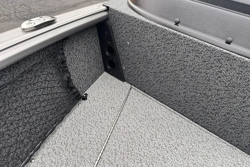 Slide: The Image of 2026 Lund 1775 Impact XS Sport boat interior with textured flooring and storage compartments. - 23