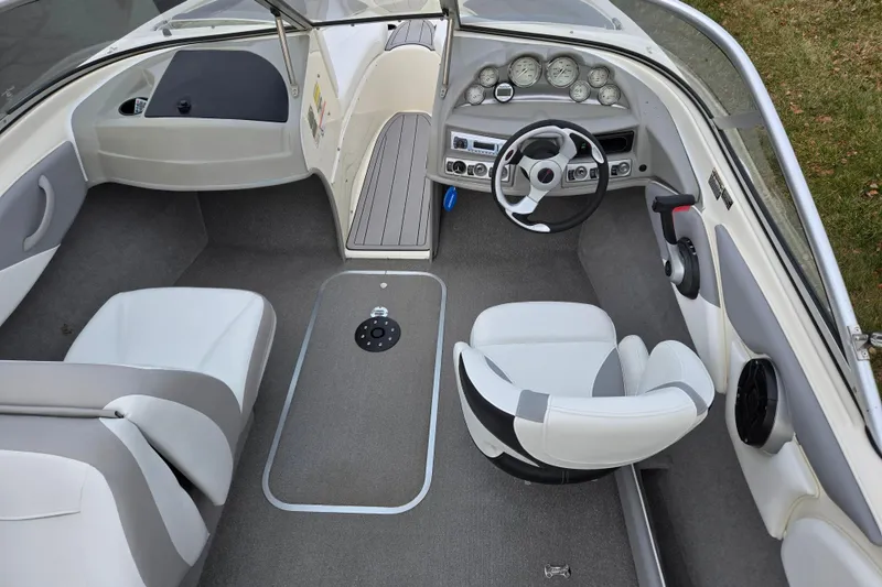 Slide: The Image of 2010 Bayliner 185 boat interior with steering wheel, dashboard, and seating. - 11