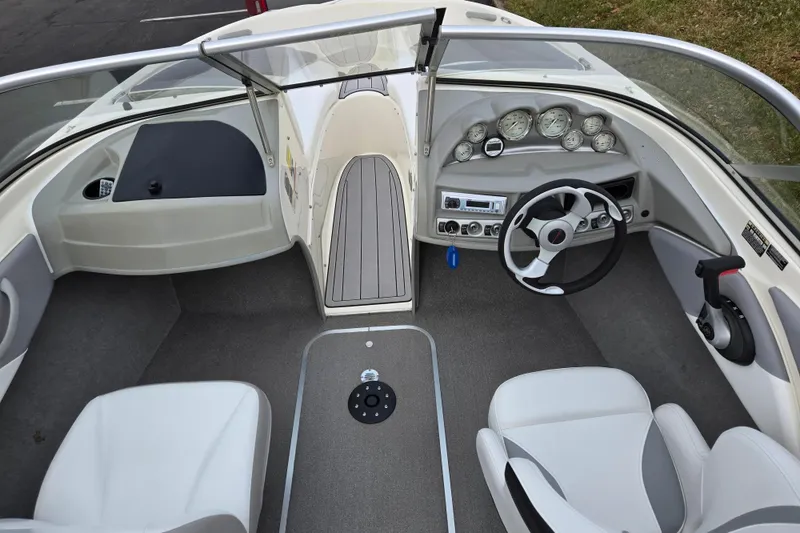 Slide: The Image of 2010 Bayliner 185 boat interior with steering wheel, dashboard, and seating. - 12