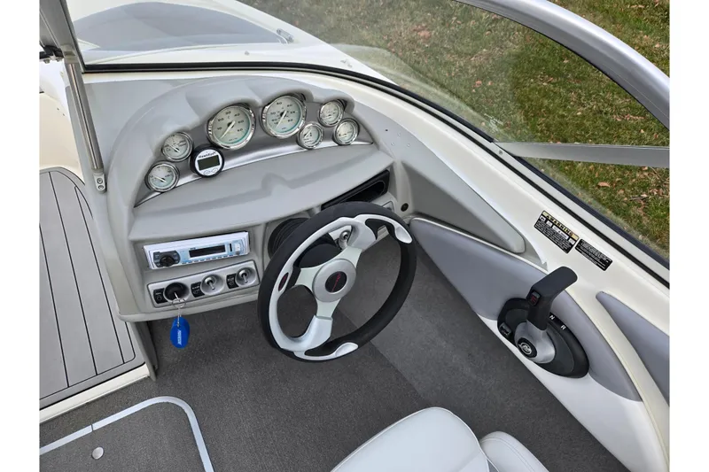 Slide: The Image of 2010 Bayliner 185 boat dashboard with steering wheel and control panel. - 14