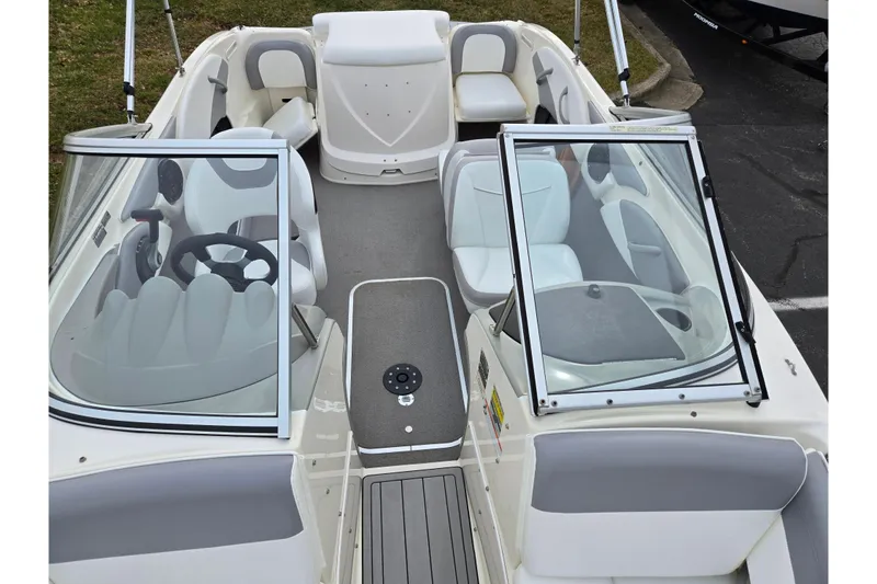Slide: The Image of 2010 Bayliner 185 boat interior with seating and steering wheel, featuring open windshield. - 19